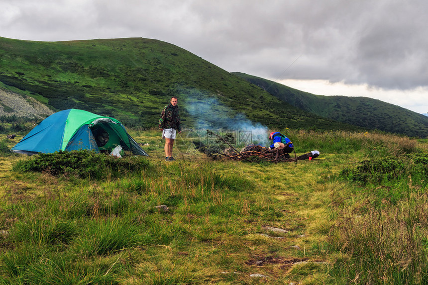 在Carpathian山的夏日旅程营地帐篷和两名男子游客在喀尔巴阡山图片