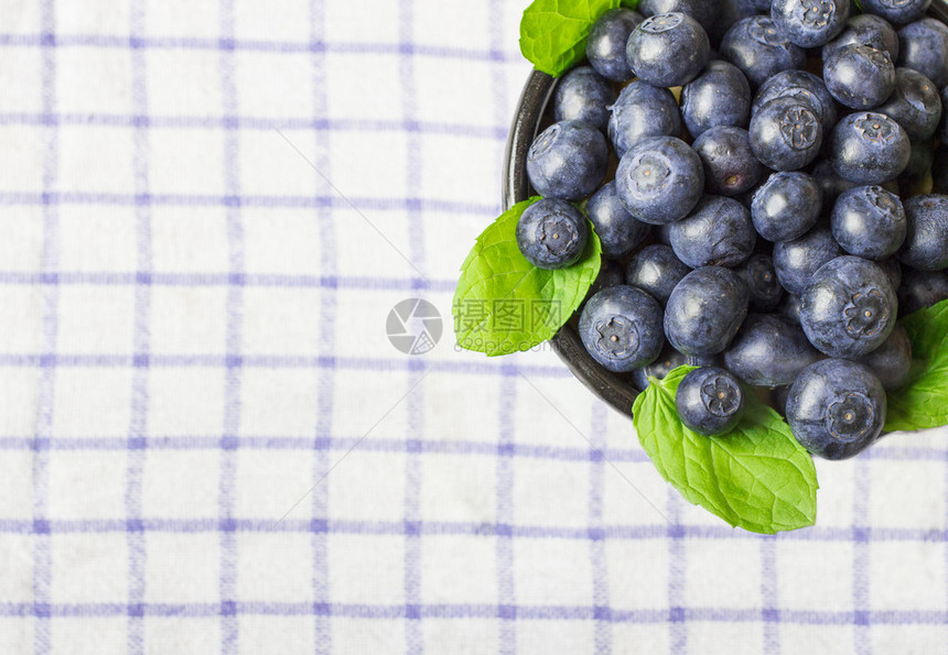 蓝莓与薄荷叶在格子蓝白毛巾上的视图图片