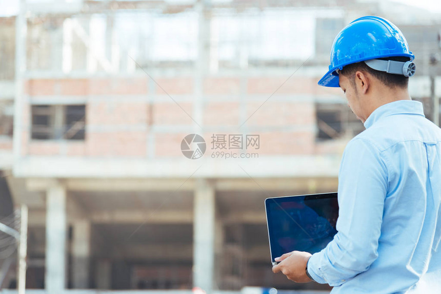 建筑工地有蓝色安全头盔的工程师拿图片