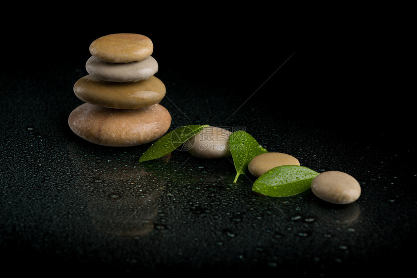 平衡石块和绿叶与食人滴ZEN石黑色背景带反射的温静概图片