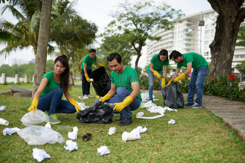 亚洲志愿者集团把垃圾捡到大垃圾袋的图片