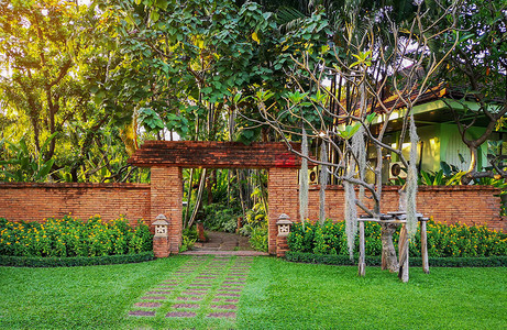 热带花园天然橙色粘土砖拱形墙入口图片