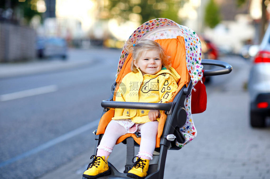 可爱的蹒跚学步的小女孩坐在婴儿车或婴儿车里散步的画像快乐可爱的宝贝孩子在户外玩得开心健康的女儿图片