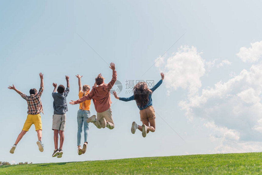多文化儿童在蓝天上跳跃图片