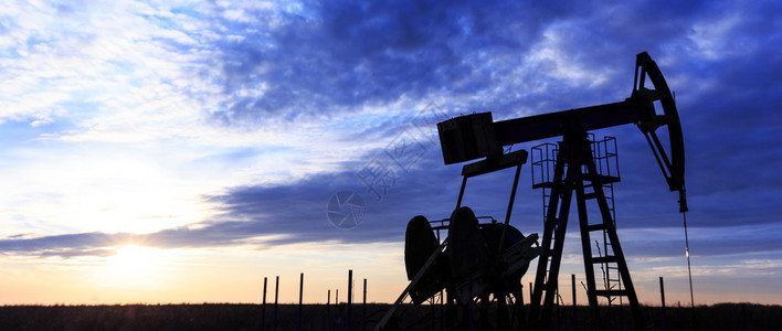 日落时的工业油气井泵背景