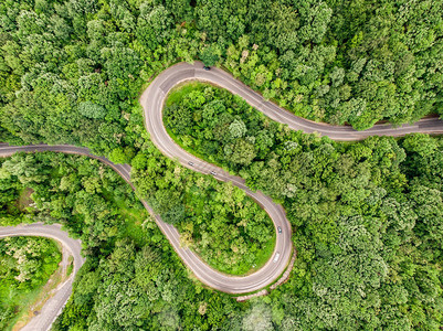 森林中间的弯曲道路使用无人驾驶图片