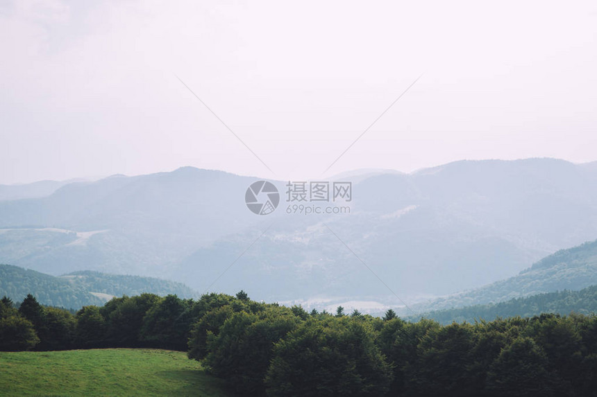 绿色山岳和草坪的绿色图景覆图片