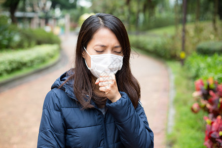 亚洲青年妇女在户外生病和戴保护面罩的图片