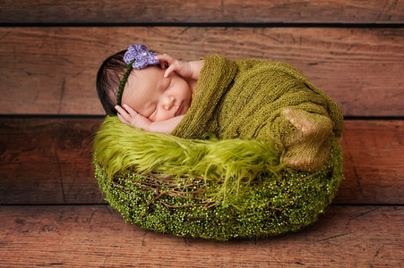 8天大的新生女婴睡在绿篮子里她被纱布图片