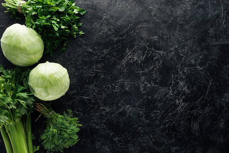 黑大理石桌顶上有绿色新鲜蔬菜的图片