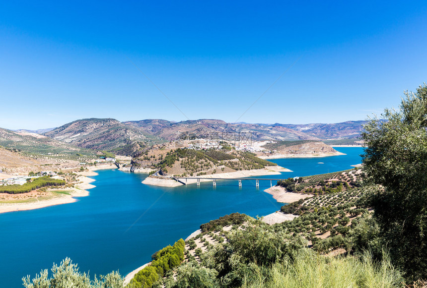 直达西班牙南部安达卢西亚Iznajar湖上远处的山丘和山坡两边图片