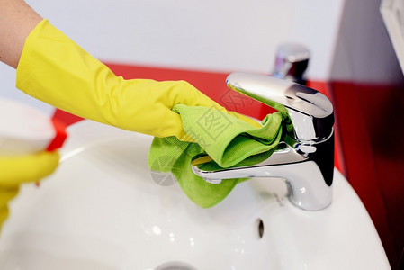 女用橡胶保护手套的手用绿布打扫图片