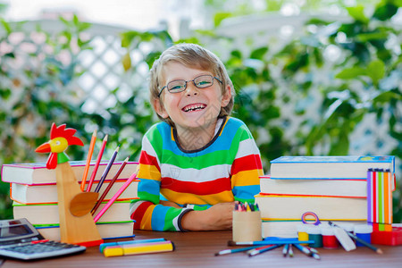 戴着眼镜的滑稽可爱的小男孩拿着蜡笔快乐的孩子和学生回到学校教育学图片