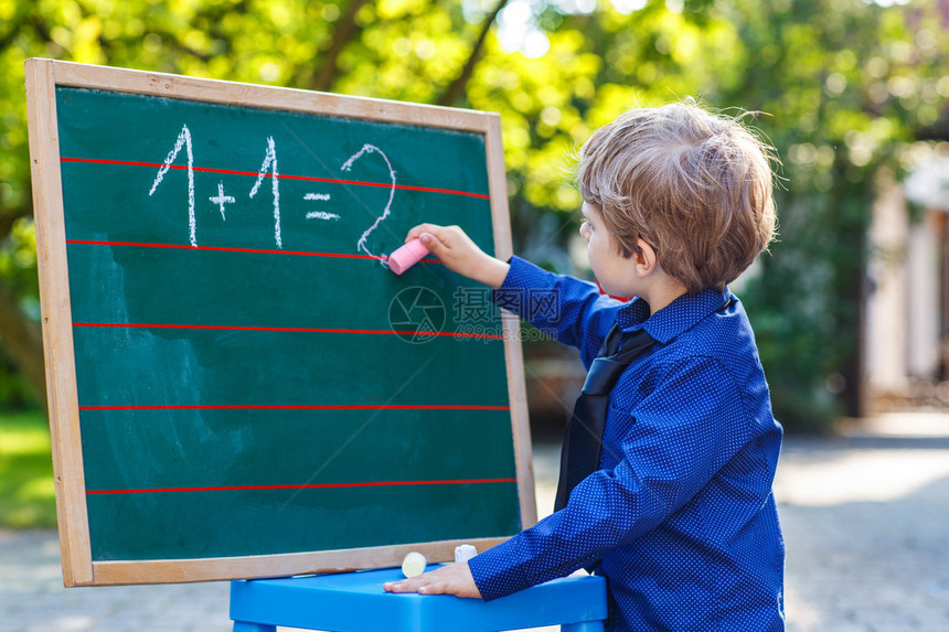 小男孩在黑板上练习数学户外图片