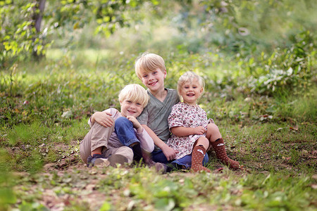森林中三个快乐微笑的小孩一个八岁的男孩他的小妹和他5岁图片