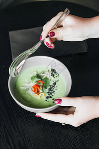 女人吃美味的绿色辣汤图片