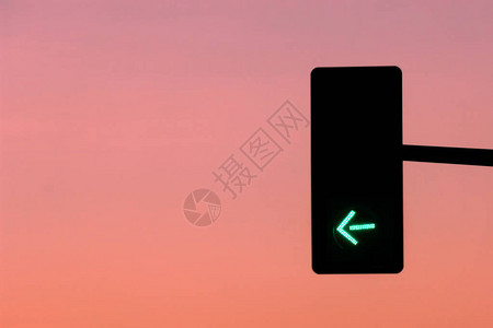 日落背景的交通路牌上的绿箭图片