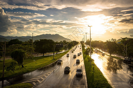 多雨潮湿的公路车辆在日落前行驶图片