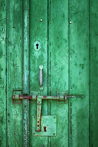 废弃房屋中装有金属锁的旧木绿色门和纸质木制绿图片