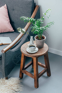 客厅木椅上的一杯咖啡和盆栽植物图片