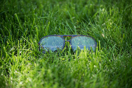 在绿色草坪上近距离观察眼镜背景图片
