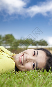 草地上微笑的亚洲年轻女子图片