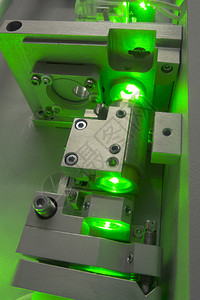 带亮绿光穿透光轨的复合实验室激光系统碎片体断图片
