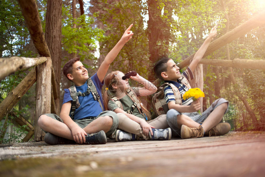 年轻童子军坐在树林图片