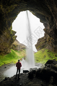 Kvernufos山峡的瀑布旅游者吸引冰岛穿红色夹克的人站立图片