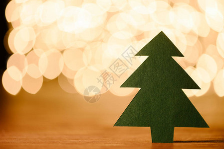 木制桌面上绿纸圣诞树的特写视图和带有复制空间图片