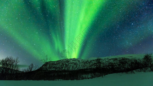 北极光北极光在夜晚的山上北极多雪的冬季景观图片
