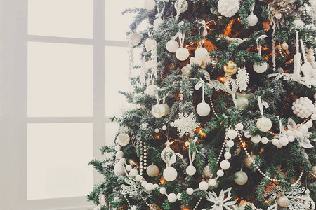 圣诞魔法背景白色客厅里装饰精美的圣诞树闪亮的灯光球小玩意和花环寒假神奇的气氛现代设计和装背景图片