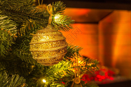 圣诞树枝的特写镜头和一个金色闪亮球形式的圣诞玩具图片