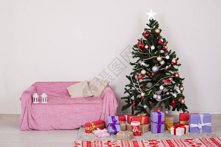 在白色房间的圣诞树配有圣诞节装饰品和图片