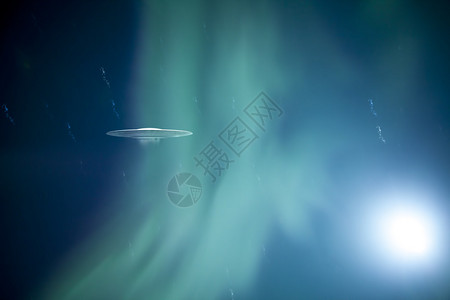 飞碟带有发光的绿色北极光和奇怪的光芒图片