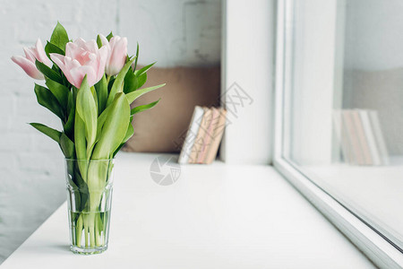 玻璃中的粉红色郁金香花束在装有图片