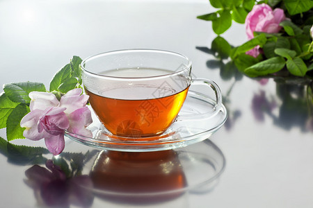 透明杯子绿色茶叶和新鲜草药花束图片