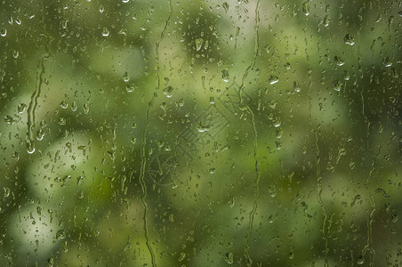 雨滴落在窗户上背景是绿树图片