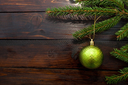绿色圣诞树枝在黑暗木质背景上图片