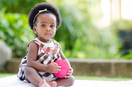 一个非裔美国人婴儿坐在院子里的肖像手图片