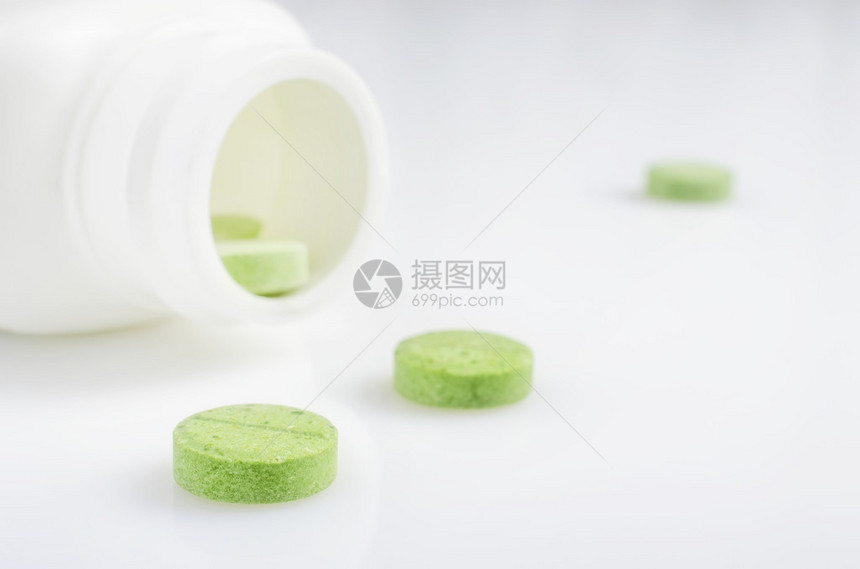 从瓶子溢出的绿色药片特写镜头图片