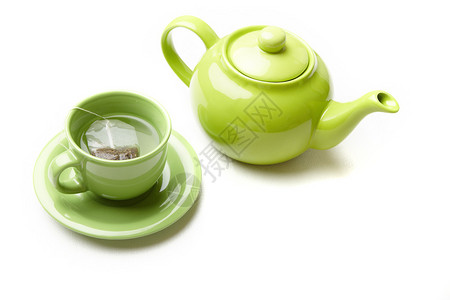 绿色茶壶和茶杯加茶袋上面图片