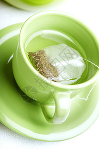 白色背景中绿色杯中的茶包图片