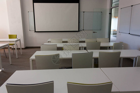 训练空内阁为墙上有板子的学生上课白桌墙壁和绿臂椅St图片