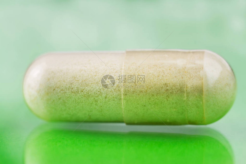 Glucosamine胶囊光彩绿色背景的食品补充药图片