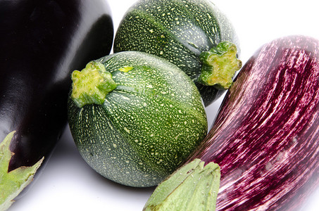 紫色和黑色茄子和两个西葫芦白色隔离图片