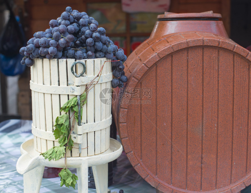 黑葡萄和棕色酒桶图片