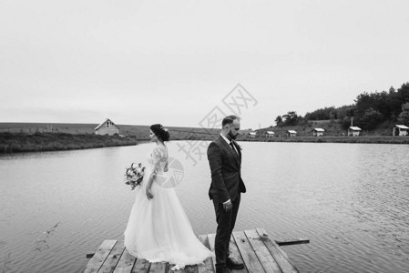 幸福的新婚夫妇在湖边的婚礼当天在码头图片
