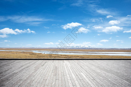 空荡的砖地和蓝天白云中的雪山图片