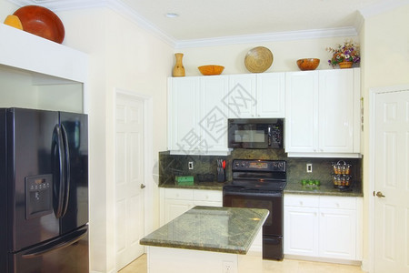 一个美丽的现代厨房的景象里面有高规格的电器白色柜子和绿图片